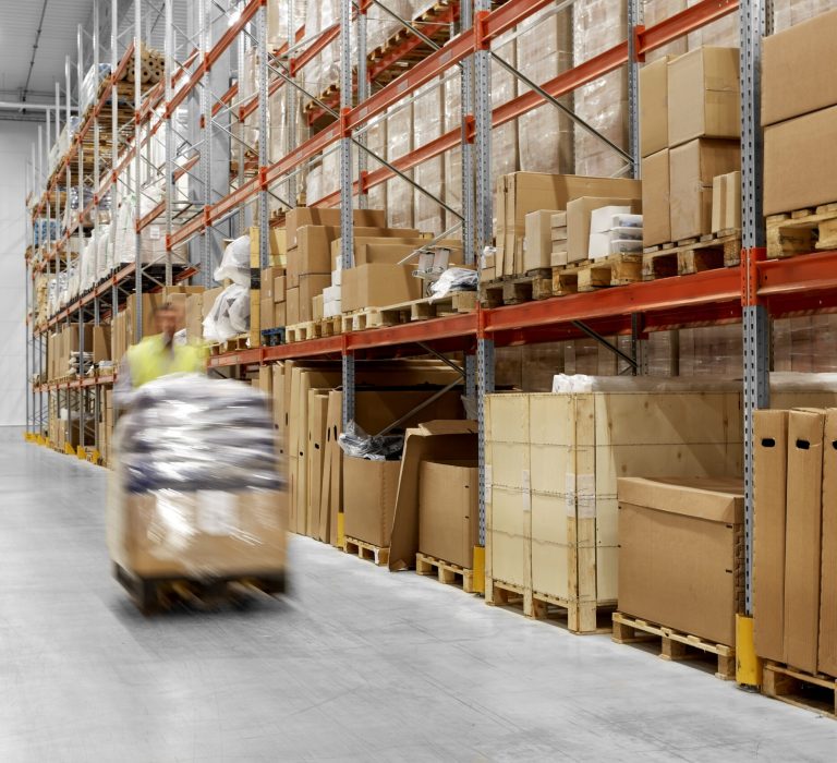 worker carrying loader with goods at warehouse logistic business, shipment and loading concept - worker carrying loader with goods at warehouse